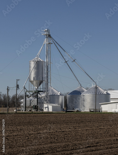 Grain bins on a farm in the Midwest. Grain bins can be used to store wheat, corn, oats, soybeans, sunflower seeds and barley.