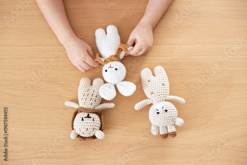 Little girl with toys at wooden table, top view