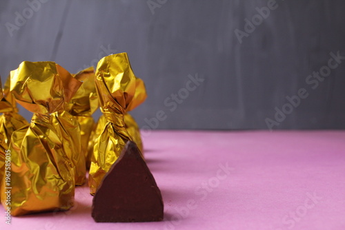 Cut chocolate truffle on a pink background with space fortext copyspace. Handmade Pastry Candy Background Concept