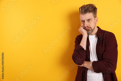 Foto Resentful man on yellow background. Space for text