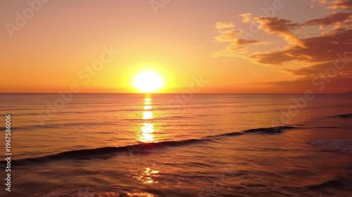 Stunning sunset over the ocean with golden light reflecting on the calm water surface, creating a peaceful and serene atmosphere at dusk