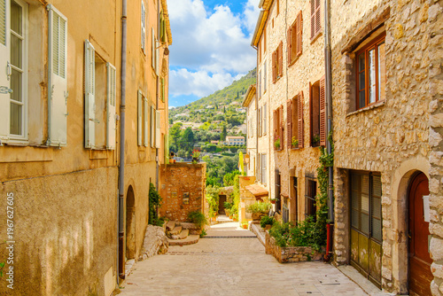 Foto A narrow pedestrian alley through historic stone buildings leading to the outer wall and scenic views, in the charming old town center of the medieval hill town of Tourrettes-sur-Loup, France