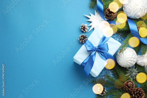 Merry Christmas and Happy New Year. Festive composition with gift and decor on light blue background, flat lay. Space for text