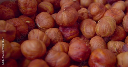 Peeled hazelnut kernels lie on a plate. Close-up
