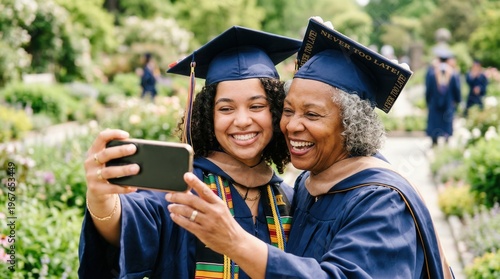 Wallpaper Mural Two women graduates smiling and taking selfie outdoors with mortarboards Torontodigital.ca