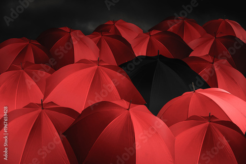 Red umbrellas together with one black umbrella, background