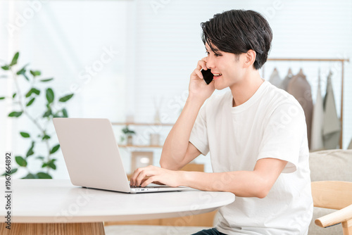 Foto Japanese man working remotely from home, making a phone call on his smartphone (
