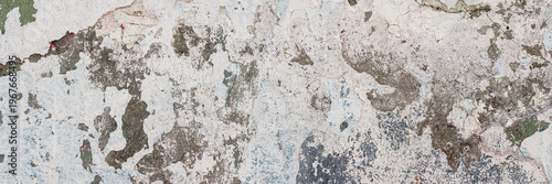 Vintage wall texture. Rough surface of the plastered concrete wall of the building. A pattern with many cracks and old faded peeling paint. Wide panoramic texture for background and design.