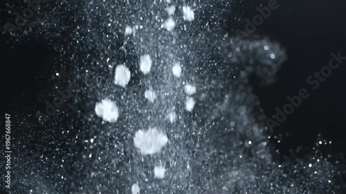 Abstract water droplets splashing on a dark black background