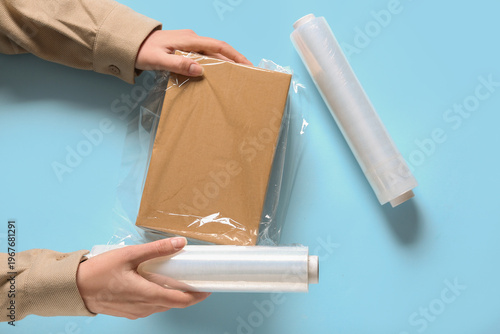 Hands wrapping box in stret...