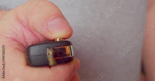 Close-up footage of a man’s hand unfolding a retractable car key 