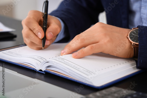 Young businessman writing i...