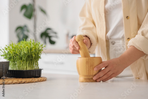 Woman with wooden mortar an...