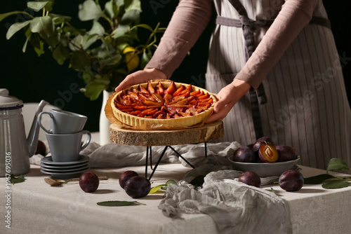 Woman holding tasty plum pi...