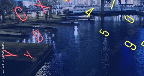 Reflecting water surface with piers and neon numerals at nighttime marina, visitors wearing coats
