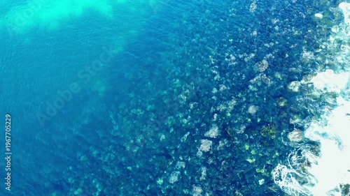 海底が見える穏やかな波打ち際を俯瞰で空撮