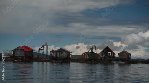 Houses on the floating Uros Islands of Lake Titicaca, Peru, surrounded by the tranquil blue waters of the world's highest navigable lake and showcasing the unique cultural heritage of the Uros people
