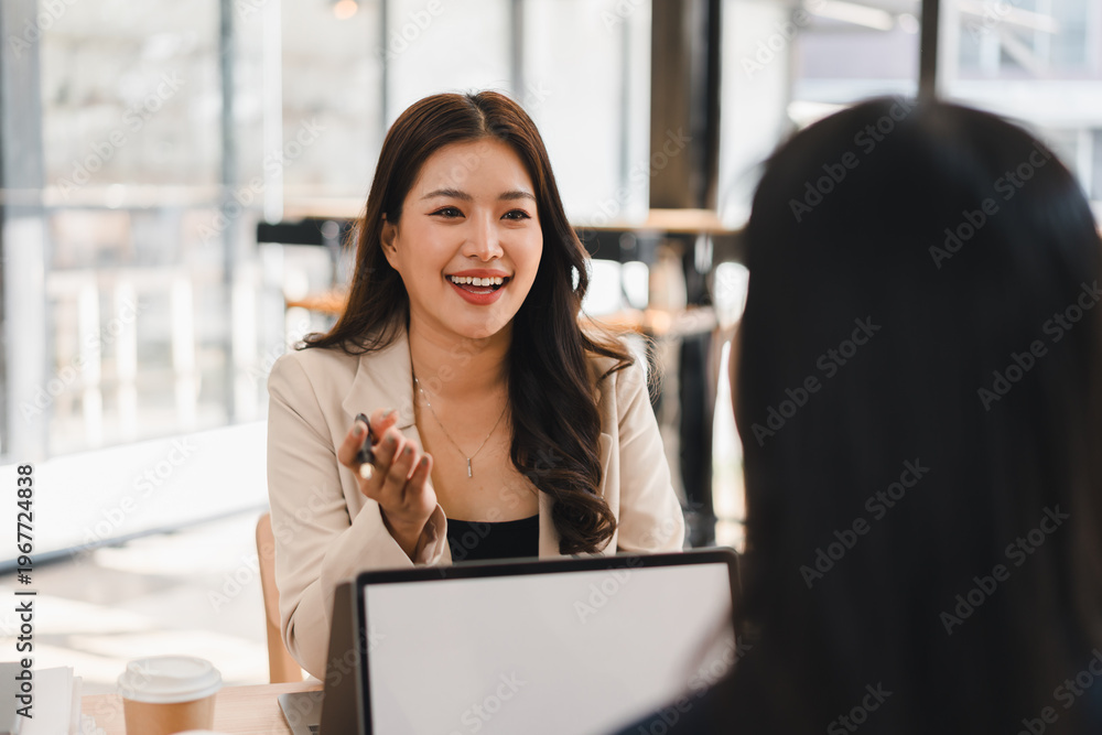 Obraz premium Asian businesswoman talking and smiling during a meeting in a modern office