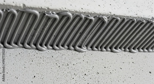 Gray silicone sealant being applied to a surface with a caulking equipment