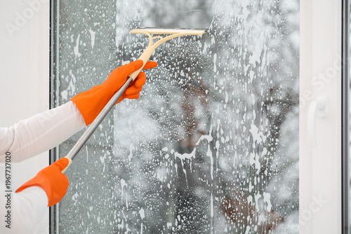 Male worker with squeegee w...