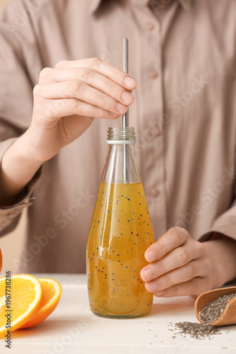 Woman adding straw into bot...