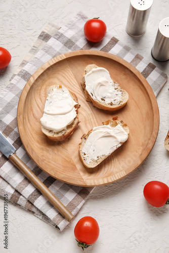 Wooden plate of tasty bruschetta with processed cheese and fresh tomatoes on white background