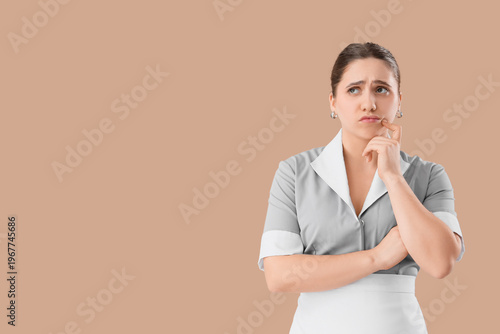 Thoughtful maid on beige ba...