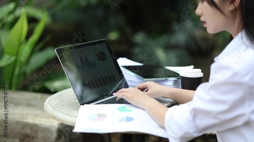 Ambitious businesswoman working on laptop in modern office, collaborating with diverse team, brainstorming ideas, planning strategy, and driving innovation and career success.

