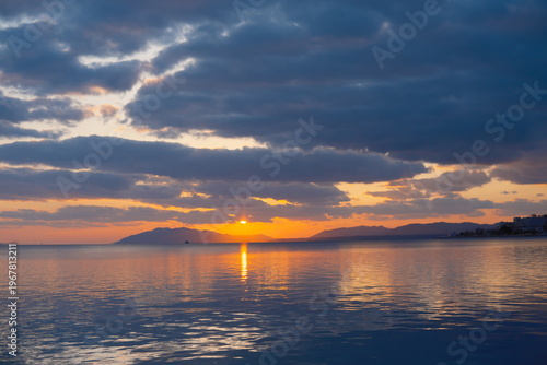 紺碧の湖に沈む太陽、水面に映るオレンジ色の光跡