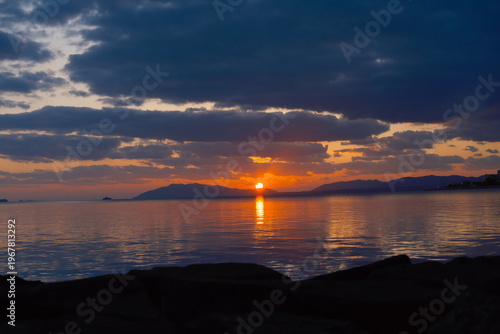 宍道湖に沈む夕日と連なる山々のシルエット、水面に映るオレンジ色の光彩