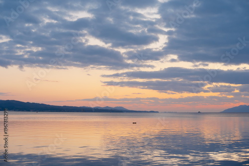 宍道湖静かな湖面に映る夕焼け空と連なる山並みの風景 