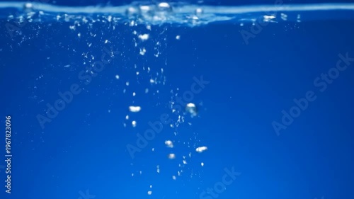 Underwater bubbles rising from an unknown source in clean, clear blue water, representing a refreshing and serene aquatic environment