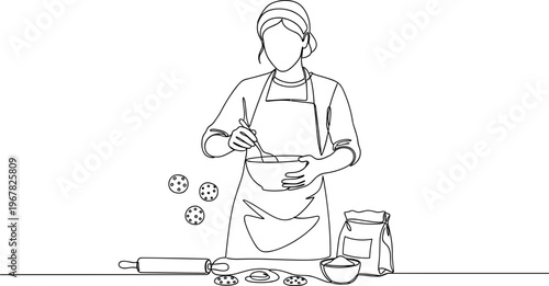 Woman wearing apron baking cookies.
