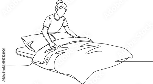Woman making a bed with pillow.