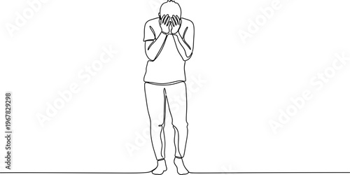 Man covering face with hands standing.