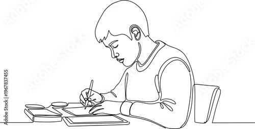 Boy sitting at desk writing book.