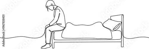 Sad person sitting on bed edge.