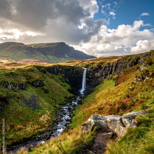 A serene waterfall cascades down a lush green valley surrounded by rugged cliffs and majestic mountains under a cloudy sky