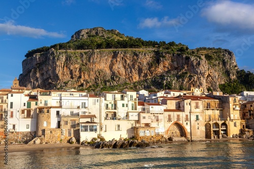 Historic Cefalu Old Mediterranean Town and Harbour Tyrrhenian Seaside View.  Dramatic La Rocca Limestone Rock Landscape Rising Above, Sicily Italy