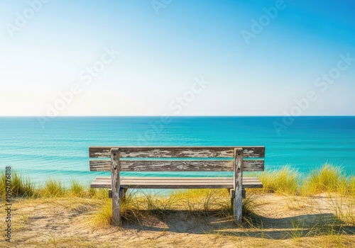 A weathered wooden bench sits atop a grassy sand dune overlooking a calm turquoise ocean under a clear sky during a peaceful summer day, turquoise, travel, summer