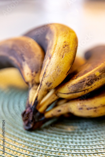 Bild auf Leinwand Selective focus on a bunch of almost overripe bananas with blackened tips on a p