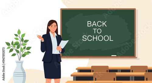 Professional female teacher stands in front of a green chalkboard with the text Back to School in an empty classroom.
