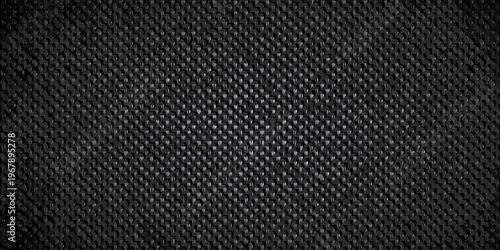 Close up of a dark textured surface resembling woven carbon fiber