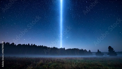 A bright light beam shoots up into the starry night sky above a misty field and forest landscape