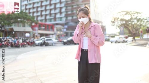 Person wearing mask in toxic urban air, monitoring pollution levels on device, highlighting health risks, environmental hazards, smog, and city pollution concerns.
