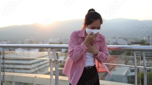 Person wearing mask in toxic urban air, monitoring pollution levels on device, highlighting health risks, environmental hazards, smog, and city pollution concerns.
