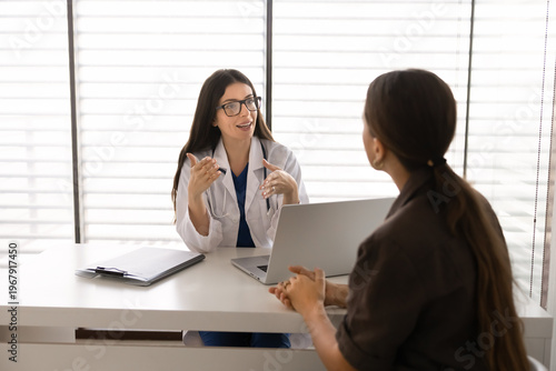 Foto Adult woman physician giving advice to patient, explaining treatment plan, healthcare insurance coverage or analysis results during medical consultation visit in clinic office