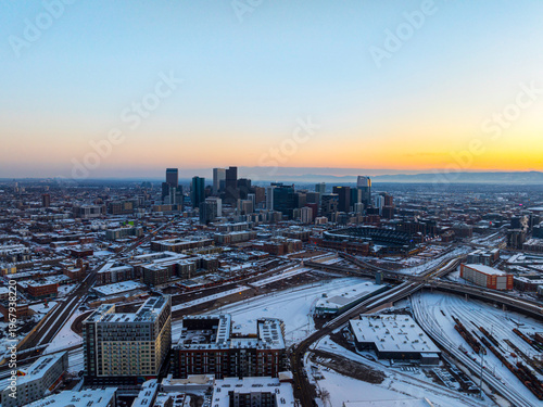 Aerial view of Denver skyline covered in snow at winter sunset