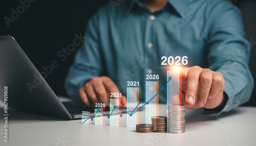 Businessman pointing at growing bar chart and graph, financial growth concept for year 2026