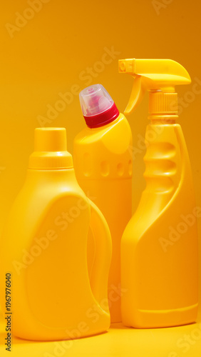 Fotografía Cleaning supplies arranged together on a yellow background showcasing their brig